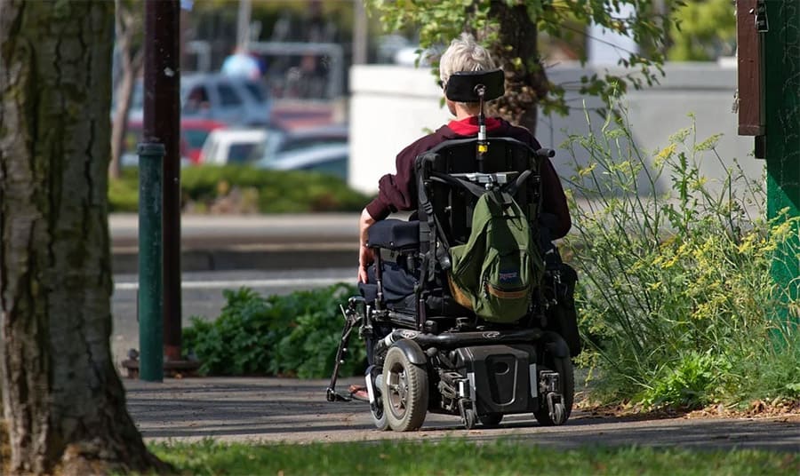 A person riding a power wheelchair outdoor