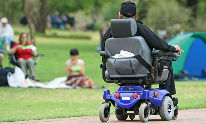 A man in a power wheelchair at a park