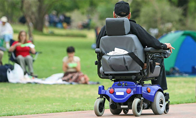 A man in a power wheelchair at a park