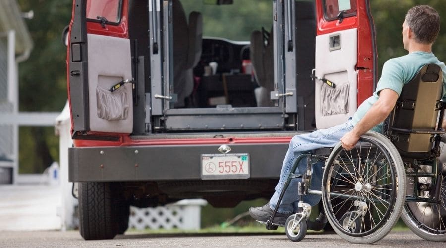 A man in a wheelchair facing the back entry of a used wheelchair van 