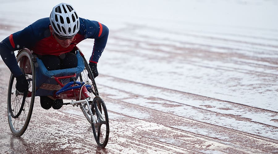 A man in a racing wheelchair on a track 