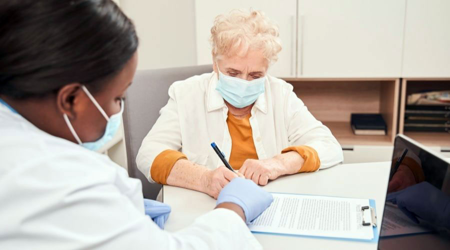 A woman filling out an Advanced Beneficiary Notice form being assisted by another woman