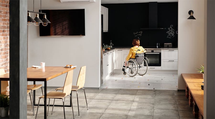 A woman in the kitchen with handicap accessible home flooring