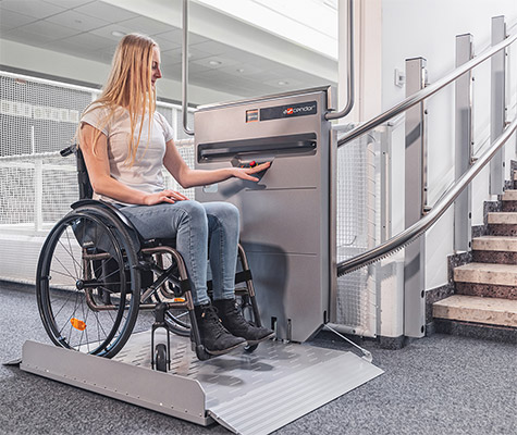 A woman in a wheelchair operating a stairlift 