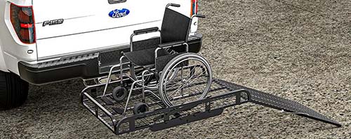 A manual wheelchair on a lift at the back of a pickup truck