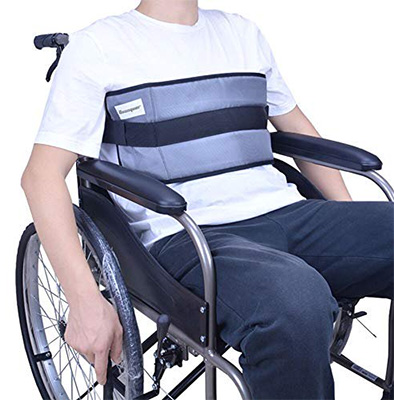 An individual in a wheelchair with harness restraint on the chest part