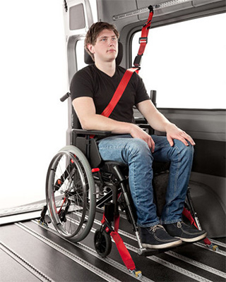 A man with wheelchair tie down straps in a car