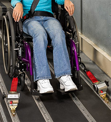 A woman with retractable wheelchair restraints in a car