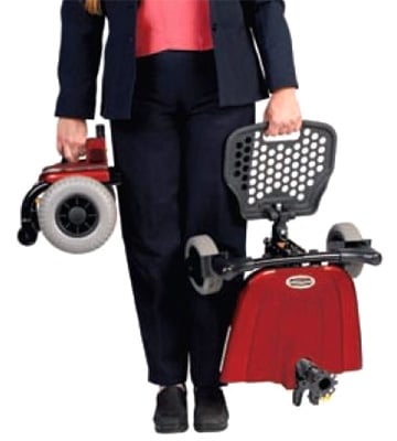 A person carrying disassembled parts of the Shoprider Jimmie Power Chair